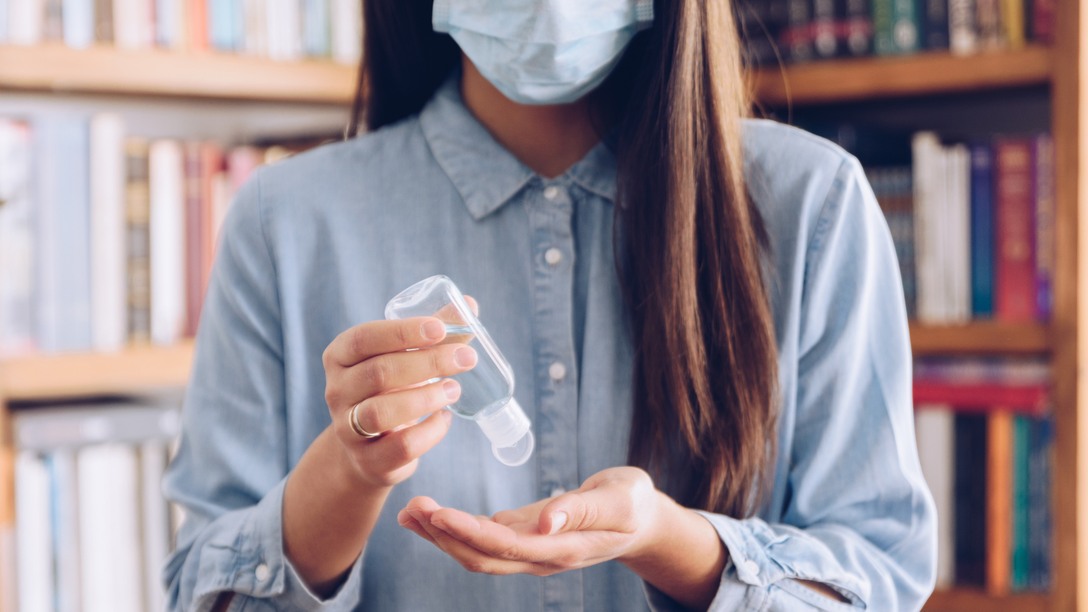 Girl wearing mask and using hand sanitizer